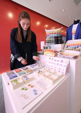 A photograph of a visitor looking at jewellery in the Tate Liverpool + RIBA North shop