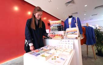 A photograph of a visitor looking at jewellery in the Tate Liverpool + RIBA North shop