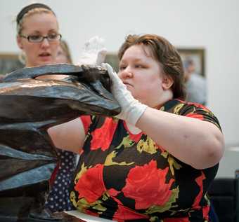 A visually impaired participant handles Ernst Barlach The Avenger 1914 while on a touch tour at Tate Modern