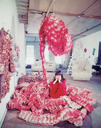 Yayoi Kusama lying on the base of My Flower Bed 