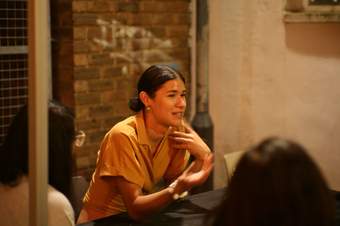 June Bellebono sits at a table facilitating a conversation