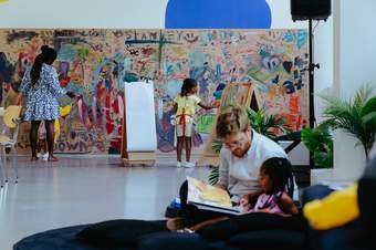 Children painting on a wall in a colourful studio space