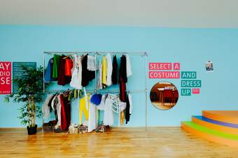 A colourful room with text on the wall saying Select a Costume and Dress Up