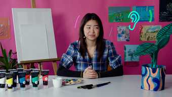 Joey Yu looking to camera listening to music against a pink background