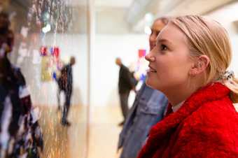 visitor looking closely at an artwork