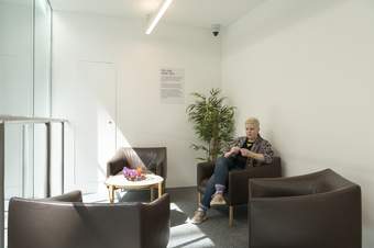 A person sitting in a room with armchairs and a coffee table