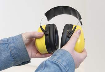 Hands holding a pair of ear defenders