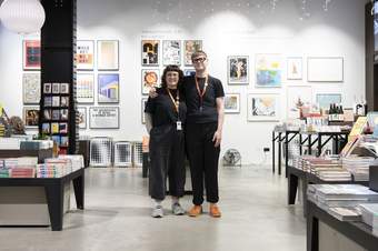 Two smiling people in a book shop