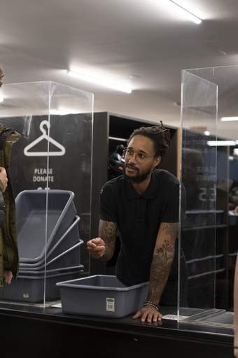 A cloakroom assistant speaking to a visitor