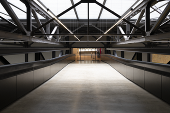 A large grey bridge between two indoor buildings